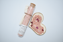 Load image into Gallery viewer, Rose pink bath soak in glass tube with heart bowl. Coconut Rose Bath Soak is a luxurious blend of sea salts and organic coconut milk. The best selling scent is the same fragrance as our companion soap bar Coconut Rose Soap Supreme - a sweet and soft mix of coconut, candy apple, raspberry, red currant, tulip, freesia, heliotrope, rose, cashmere musk, vanilla, and amber. Skin Joy Soap Murfreesboro Tennessee