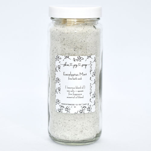 Light green bath salt soak in glass jar. Eucalyptus Mint Bath Soak is a refreshing blend of sea salts, epsom salt and fine fragrance. Experience a unique twist on the classic eucalyptus mint scent with this customer favorite, featuring rosemary, peppermint, spearmint and refreshing eucalyptus.  Skin Joy Soap Murfreesboro Tennessee