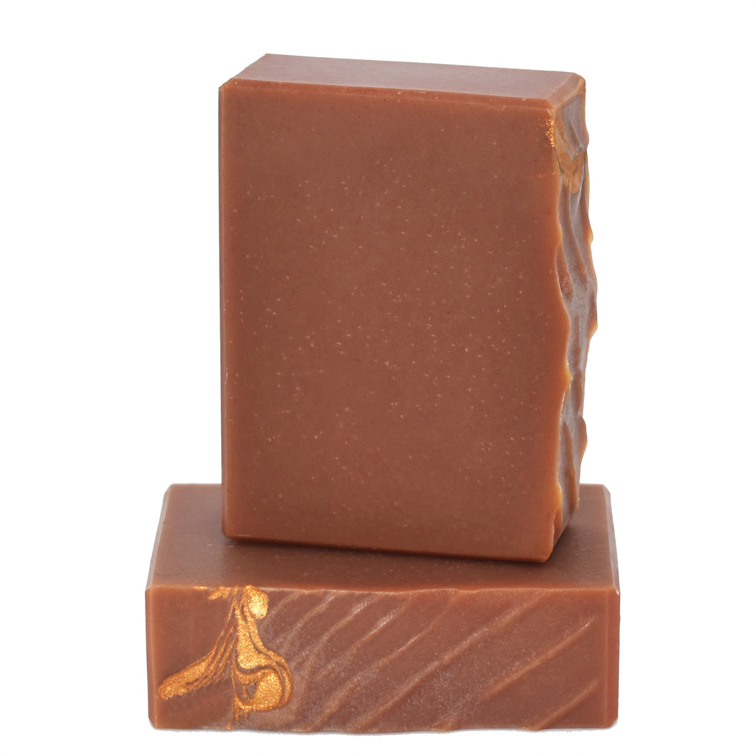 Red Brazilian clay bar soap with gold textured top. Handcrafted Luxury Natural Soap Made for Men: Palo Santo Soap Supreme is a complex blend of Moroccan cedarwood, rum,  vetiver and tonka bean; the essence of this masculine fragrance is warm and woody.  This soap supreme bar is formulated of botanical oils, cocoa butter, organic coconut milk, red Brazilian clay, and luxurious silk fibers.  Skin Joy Soap Murfreesboro Tennessee
