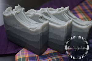 Shades of gray layered artisan natural soap bars displayed with colorful neck ties. Handmade soap with gradient layers of activated charcoal, Shades bar is formulated of nourishing botanical oils infused with luxurious silk amino acids and activated charcoal for a deep pore detox. The fragrance profile is masculine blend of oak, cedar, mandarin, musk and amber. Skin Joy Soap Murfreesboro Tennessee